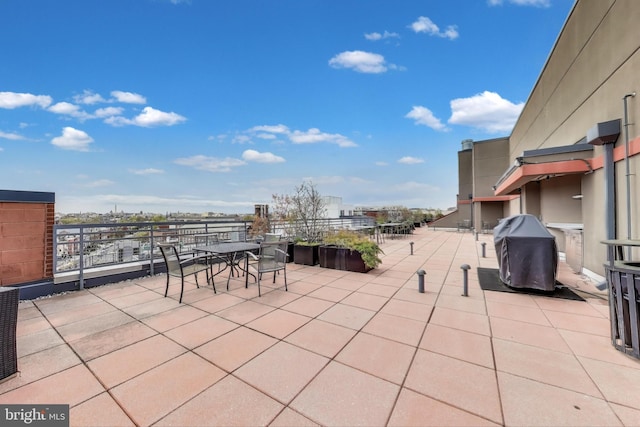 view of patio with area for grilling, a view of city, and outdoor dining area