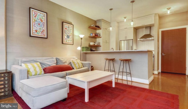 living area with baseboards and wood finished floors