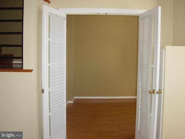 hallway with baseboards and wood finished floors