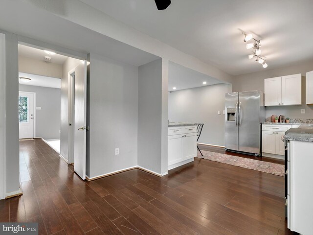 kitchen featuring stainless steel fridge with ice dispenser, white cabinets, and baseboards