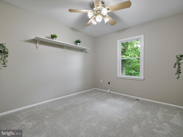 carpeted empty room featuring baseboards and a ceiling fan