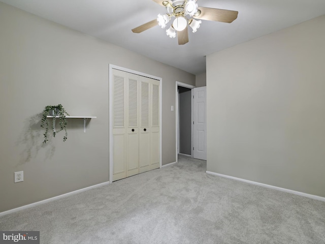 unfurnished bedroom with carpet, baseboards, a closet, and ceiling fan