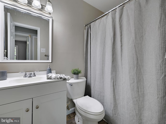 full bath with toilet, vanity, and wood finished floors