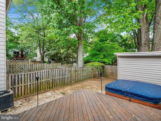wooden terrace with a covered hot tub, a fenced backyard, and cooling unit