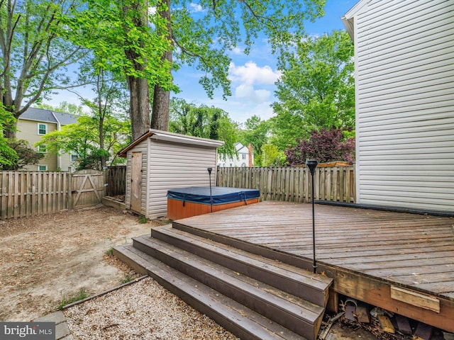 wooden terrace with a hot tub and a fenced backyard