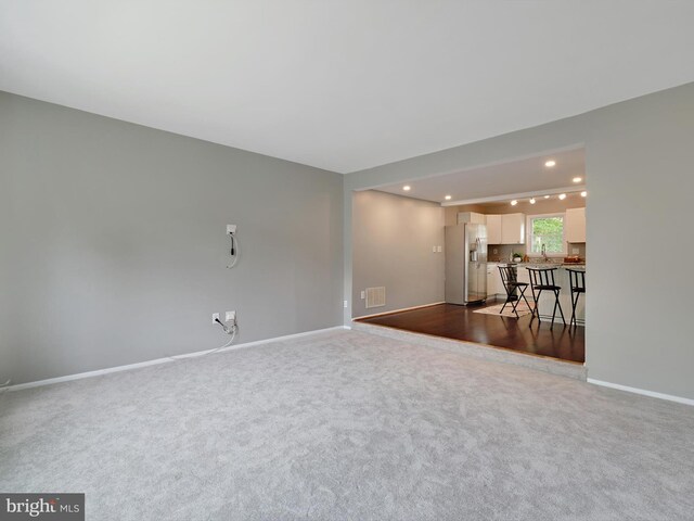 empty room featuring baseboards, recessed lighting, and carpet