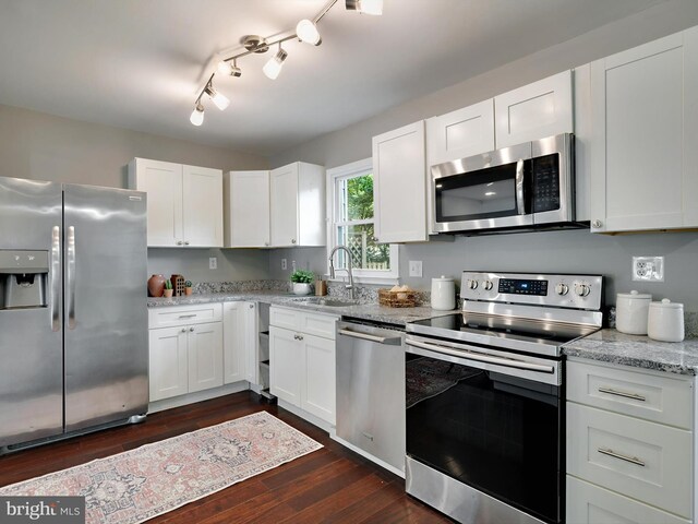 kitchen with appliances with stainless steel finishes, dark wood-style floors, white cabinets, and a sink