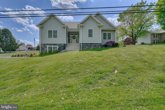 raised ranch with stone siding and a front lawn