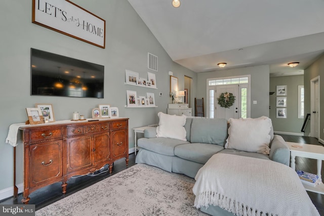 living room with baseboards, lofted ceiling, wood finished floors, and visible vents