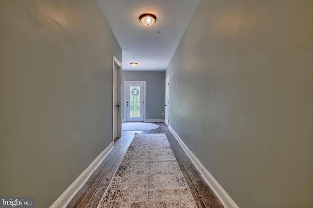 corridor featuring wood finished floors and baseboards