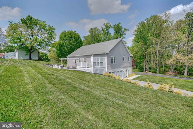 rear view of property with a yard and a garage