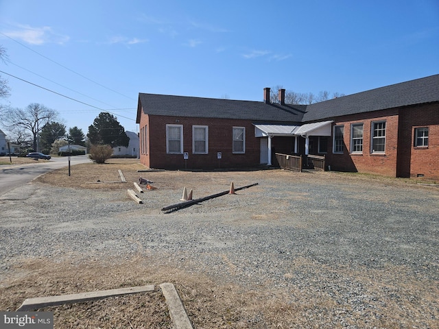 back of property featuring brick siding