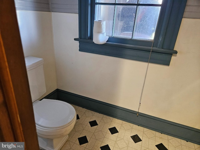 half bathroom with toilet and baseboards