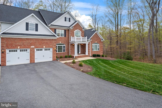 765 Blueberry Ct, Huntingtown, MD 20639 - view of front of house featuring a balcony, driveway, a front lawn, and brick siding
