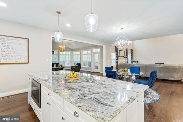 765 Blueberry Ct, Huntingtown, MD 20639 - kitchen featuring visible vents, open floor plan, stainless steel microwave, dark wood-type flooring, and light stone counters