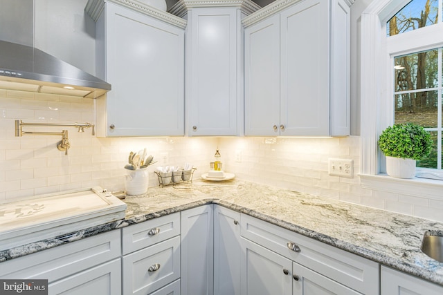 765 Blueberry Ct, Huntingtown, MD 20639 - kitchen featuring white cabinets, tasteful backsplash, light stone countertops, and wall chimney exhaust hood