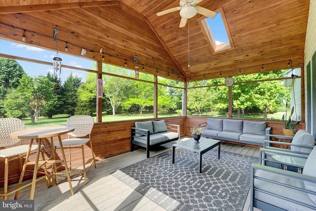 sunroom featuring ceiling fan, a skylight, and outdoor lounge area