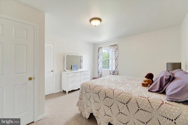 bedroom with baseboards and light carpet