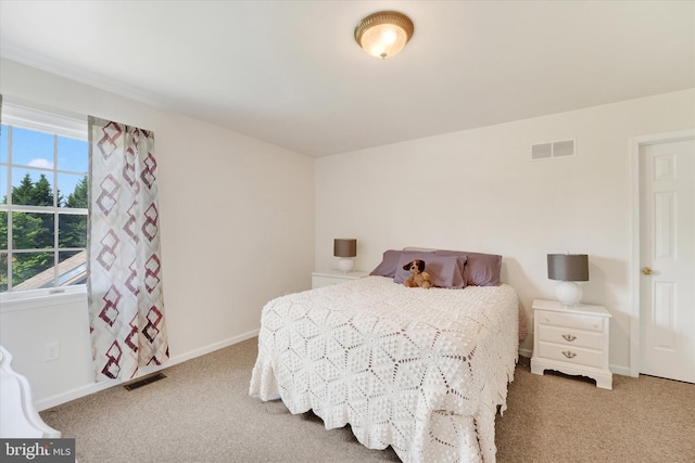carpeted bedroom featuring baseboards and visible vents