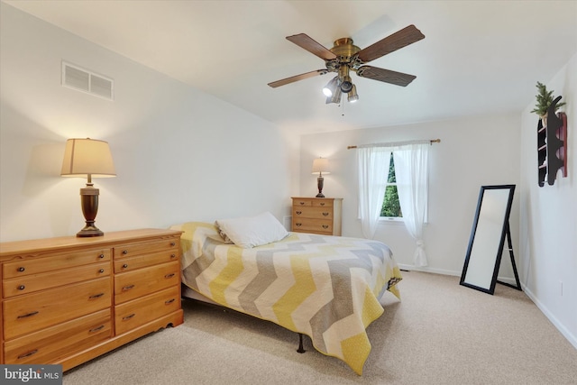 bedroom featuring visible vents, baseboards, ceiling fan, and light colored carpet