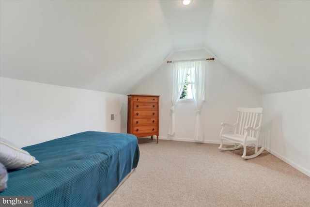 carpeted bedroom featuring baseboards and vaulted ceiling