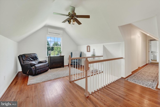 additional living space with ceiling fan, baseboards, a wall unit AC, wood finished floors, and lofted ceiling