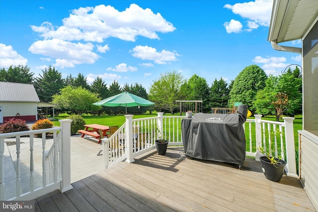 wooden terrace with a yard and grilling area