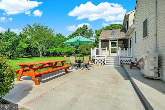 view of patio / terrace featuring ac unit, outdoor dining space, a sunroom, and a wooden deck
