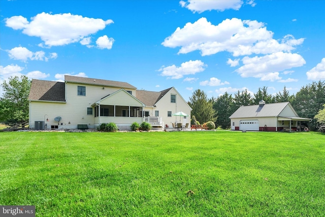back of house with a garage, a lawn, central AC unit, and a sunroom