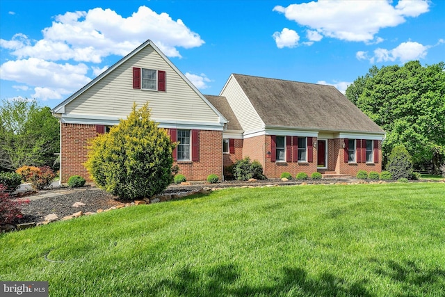 view of front of property with brick siding, a shingled roof, and a front lawn