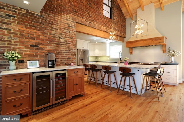 451 E Hamilton Ave, State College, PA 16801 - kitchen featuring wine cooler, a kitchen island with sink, a breakfast bar, light wood-style floors, and high vaulted ceiling
