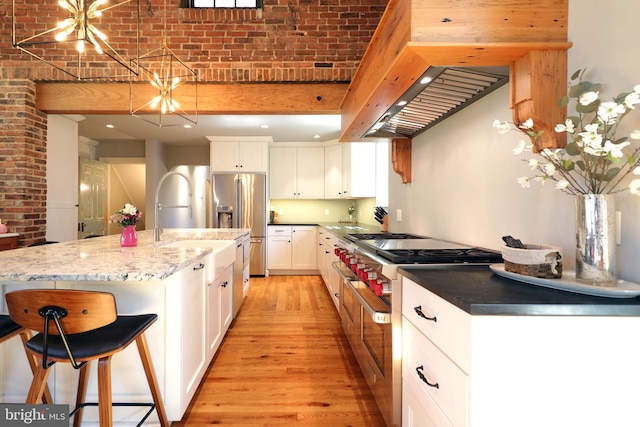 451 E Hamilton Ave, State College, PA 16801 - kitchen with white cabinets, a sink, light wood-style flooring, stainless steel appliances, and a kitchen bar