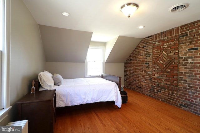 451 E Hamilton Ave, State College, PA 16801 - bedroom featuring brick wall, radiator, wood finished floors, vaulted ceiling, and visible vents