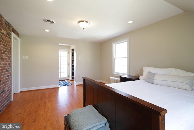 451 E Hamilton Ave, State College, PA 16801 - bedroom featuring brick wall, visible vents, light wood-type flooring, baseboards, and radiator heating unit
