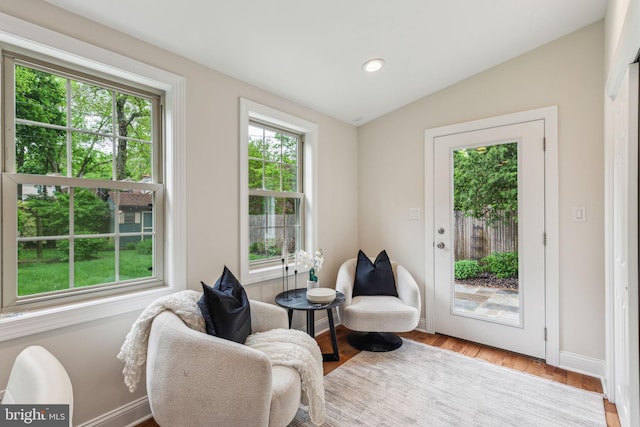 sitting room with baseboards, lofted ceiling, recessed lighting, and wood finished floors