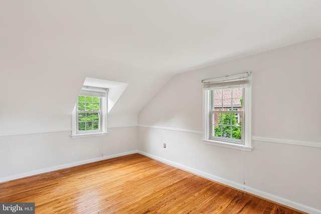 bonus room featuring lofted ceiling, baseboards, and wood finished floors