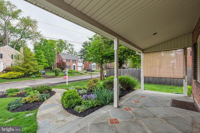 view of patio / terrace featuring fence and a residential view