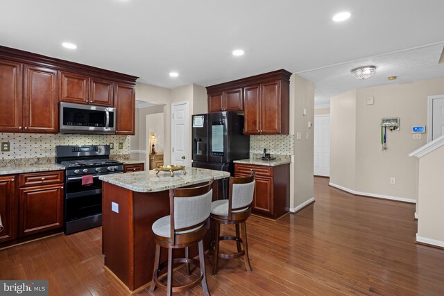kitchen featuring stainless steel microwave, black fridge with ice dispenser, decorative backsplash, gas range, and dark wood finished floors