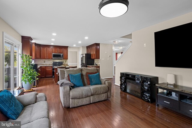 living room with dark wood-style floors and recessed lighting