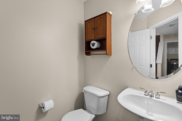 half bath featuring toilet and a sink