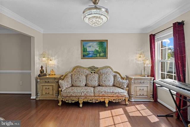 sitting room with a notable chandelier, crown molding, and wood-type flooring