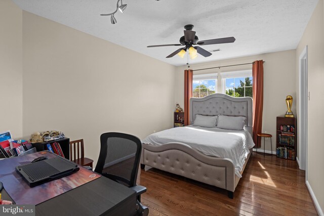 bedroom featuring baseboards, visible vents, hardwood / wood-style flooring, and a ceiling fan