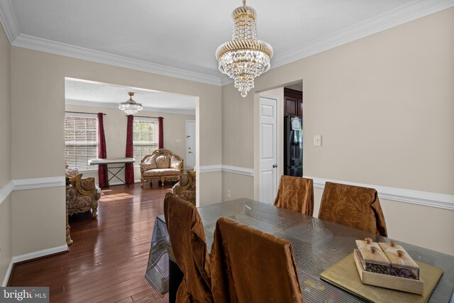 dining space featuring baseboards, ornamental molding, an inviting chandelier, and dark wood-type flooring