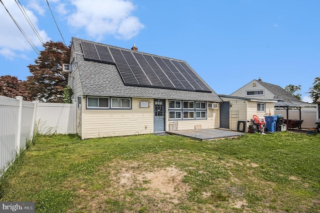 59 Granite Rd, Levittown, PA 19057 - rear view of house with roof mounted solar panels, a chimney, and roof with shingles