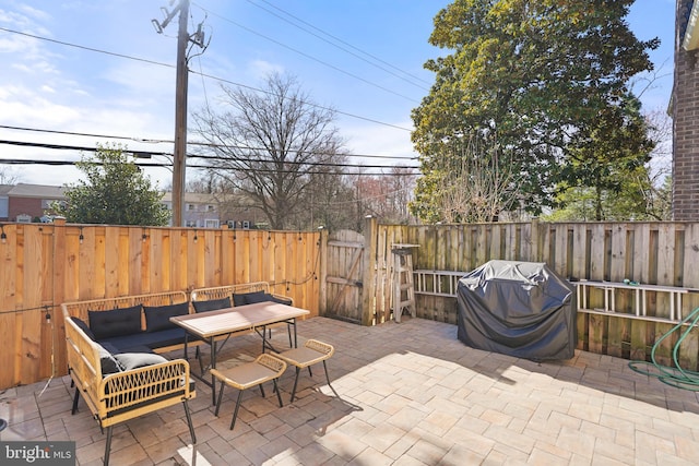 view of patio / terrace with outdoor lounge area, a gate, a fenced backyard, and a grill