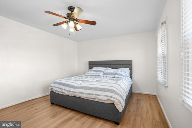 bedroom featuring baseboards, ceiling fan, and wood finished floors