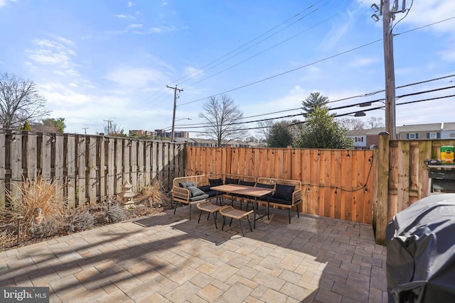 view of patio featuring a grill, an outdoor living space, and a fenced backyard