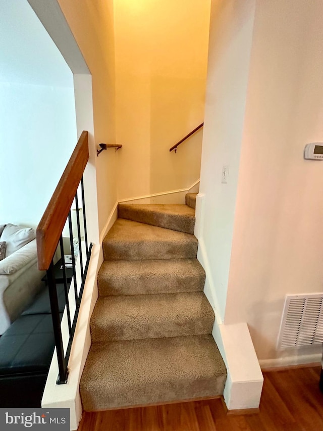 staircase with wood finished floors and baseboards