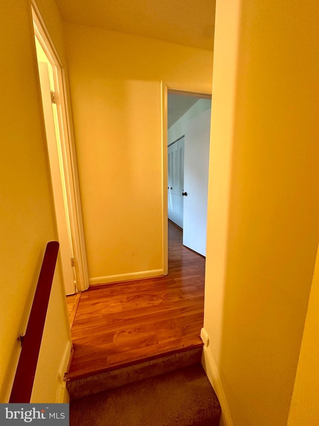 hallway with wood finished floors and baseboards