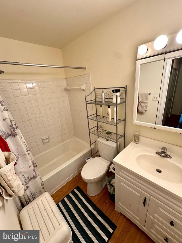 bathroom featuring wood finished floors, toilet, washtub / shower combination, and vanity